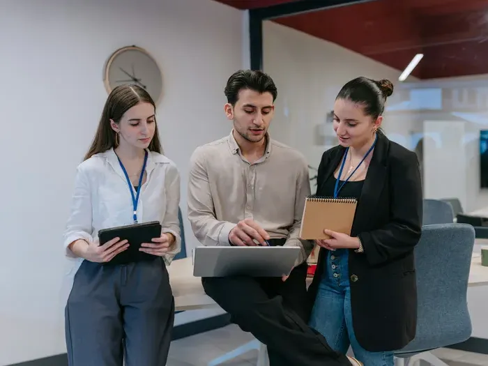 Colleagues collaborate with a tablet and laptop in an office, as CityBiz Spotlight connects people to services
